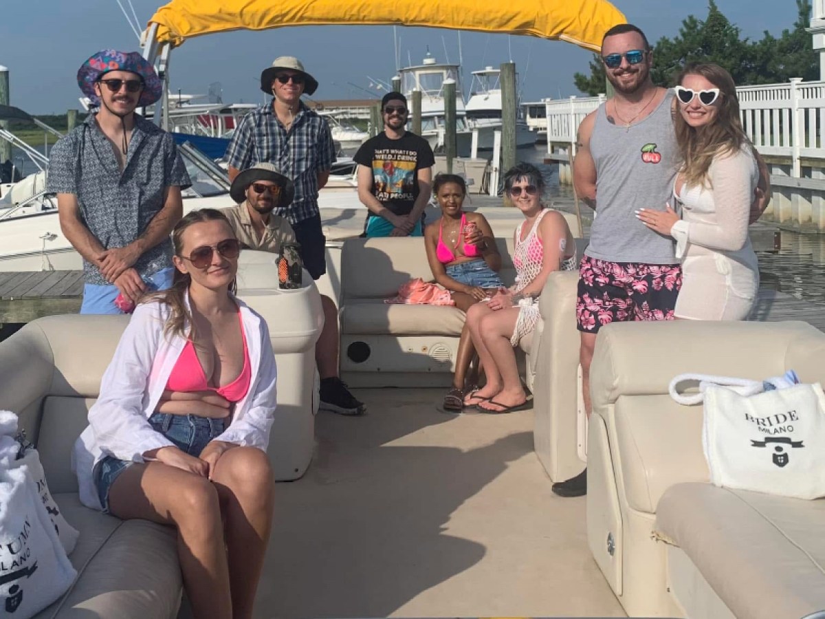 a group of people sitting around a car